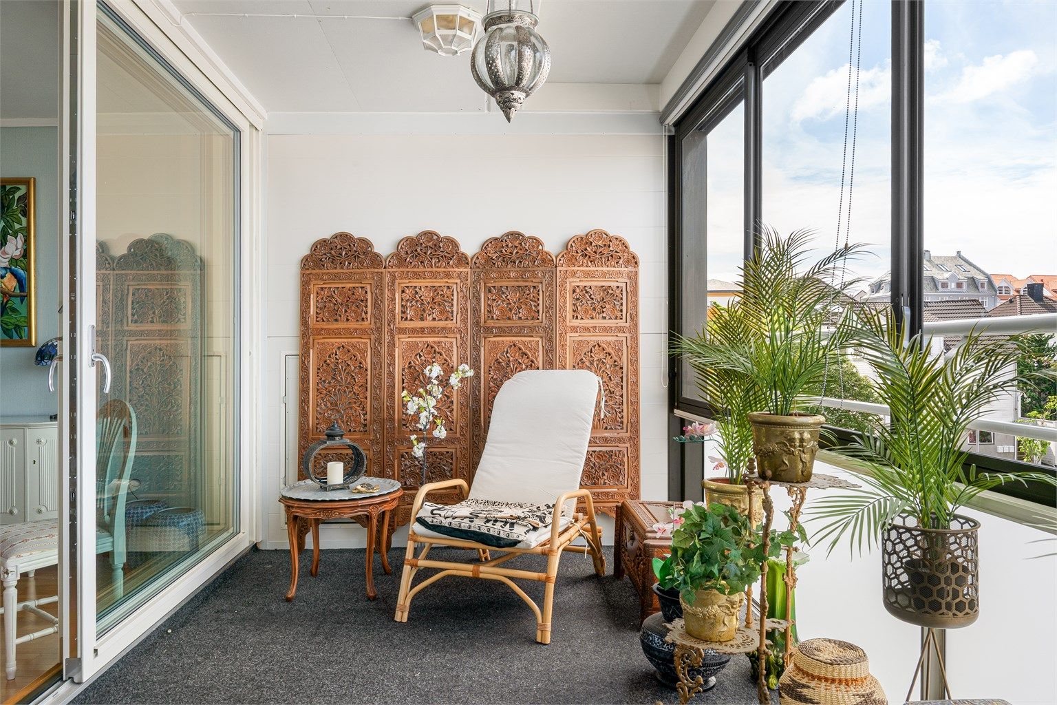 Det er store skyvedører i glass mellom stue og balkong