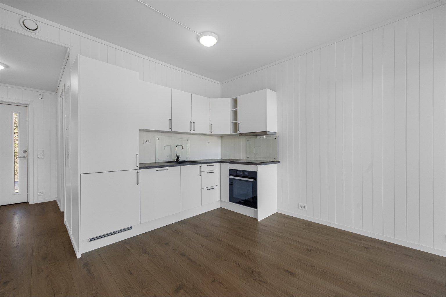 Integrerte hvitevarer medfølger, herunder komfyr, koketopp, oppvaskmaskin og kombiskap (kjøl/frys).