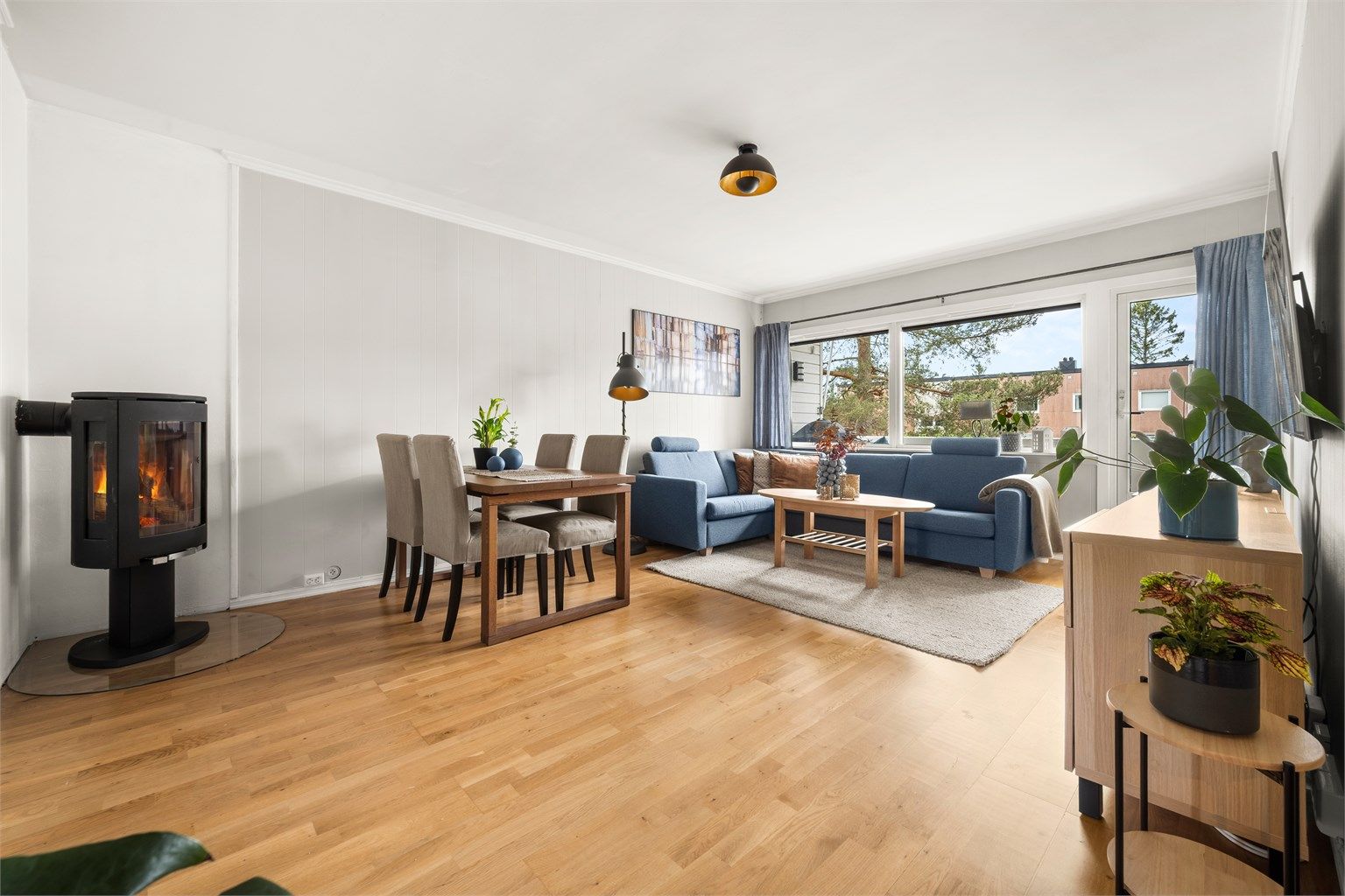 Flott stue med god plass til både sofagruppe og spisebord. Vedovn med glassdør gir en lun atmosfære.
Foto: Martine Eren Jacobsen