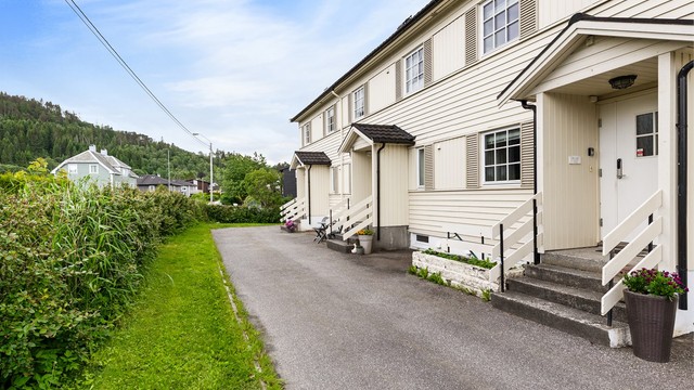Asfaltert gårdsplass foran boligen med enkel adkomst.
