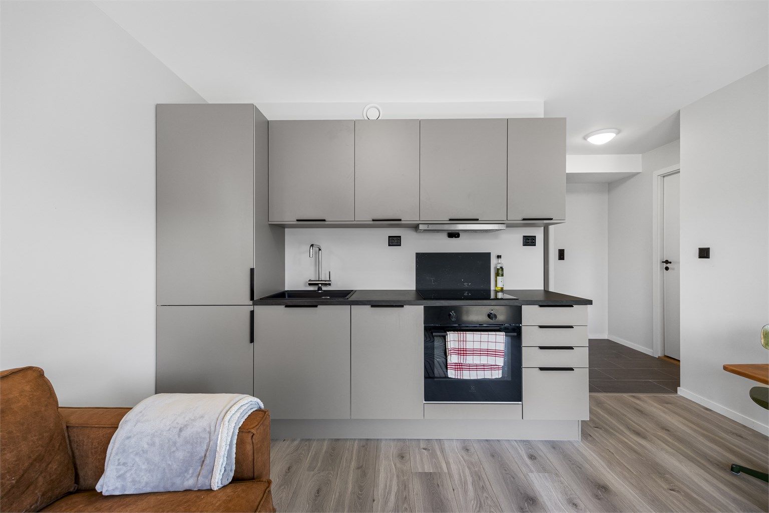 Kjøkkenet er utstyrt med integrert kjøl/fryseskap, oppvaskmaskin, induksjonstopp og stekeovn.