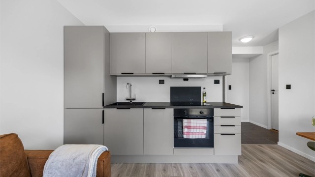 Kjøkkenet er utstyrt med integrert kjøl/fryseskap, oppvaskmaskin, induksjonstopp og stekeovn.