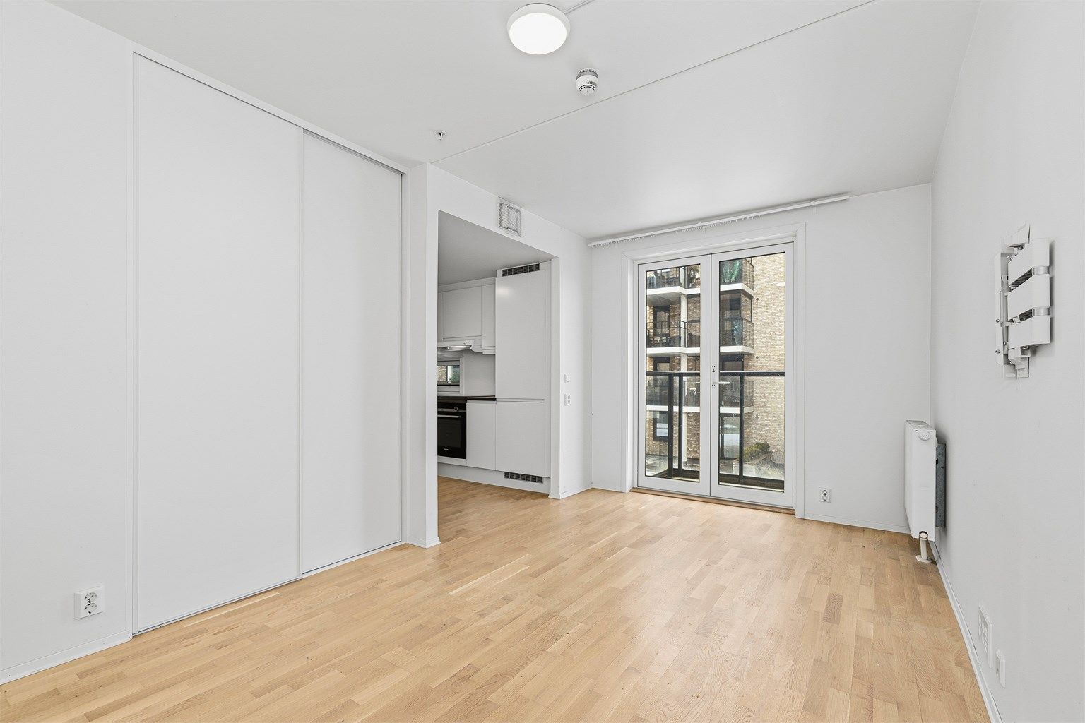 Oppholdsrommet har gjennomgående parkett på gulv og plass til både sittegruppe og soveavdeling.