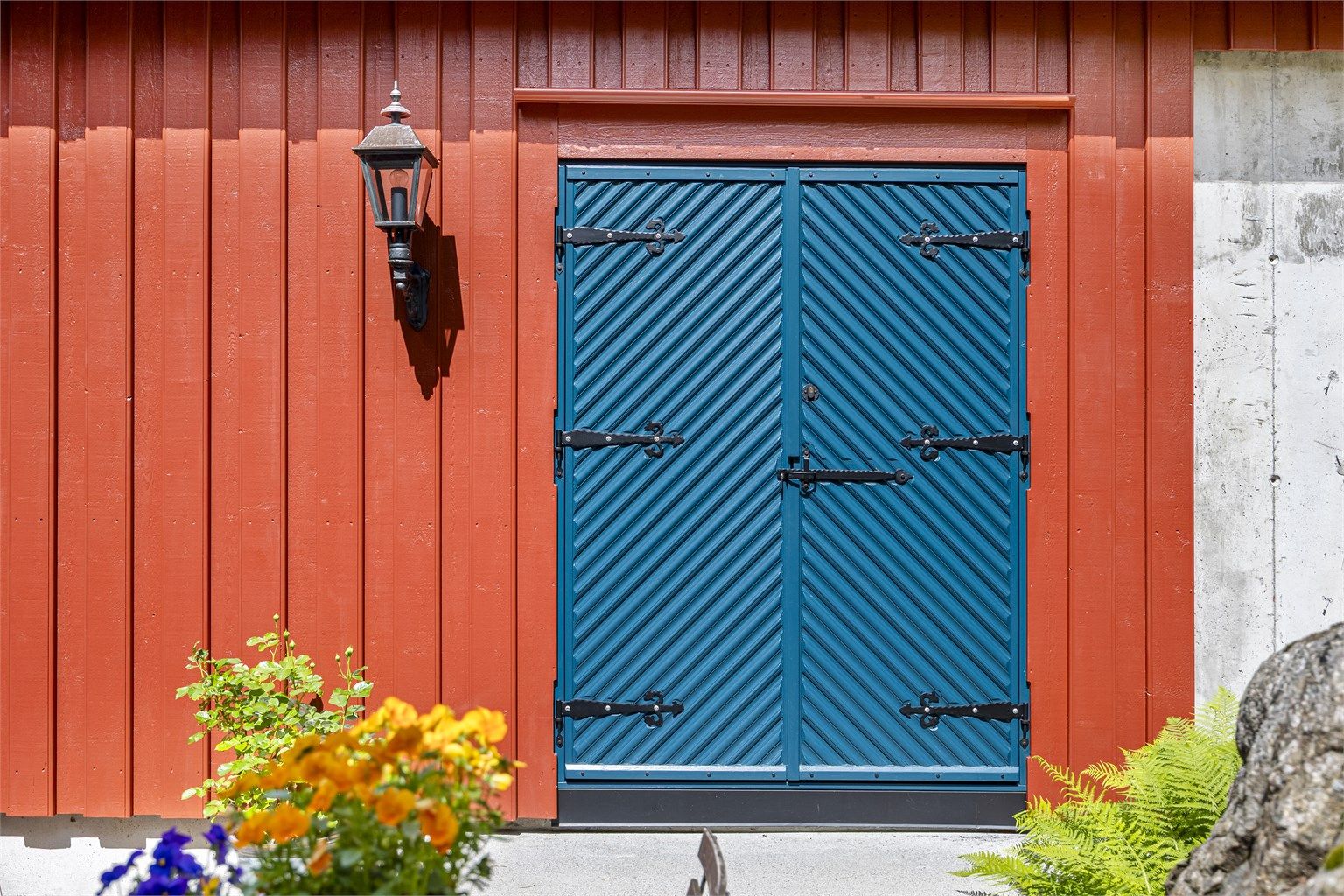 Detaljer fra fasaden med dører inspirert av eldre byggetradisjon.