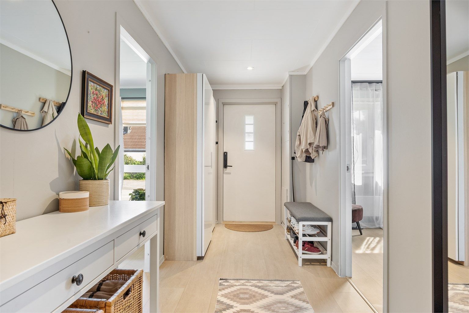 Romslig entré med skyvedørsgarderobe for effektiv oppbevaring av yttertøy.