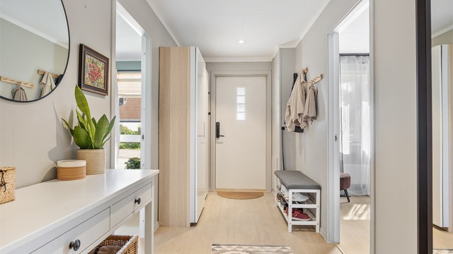 Romslig entré med skyvedørsgarderobe for effektiv oppbevaring av yttertøy.