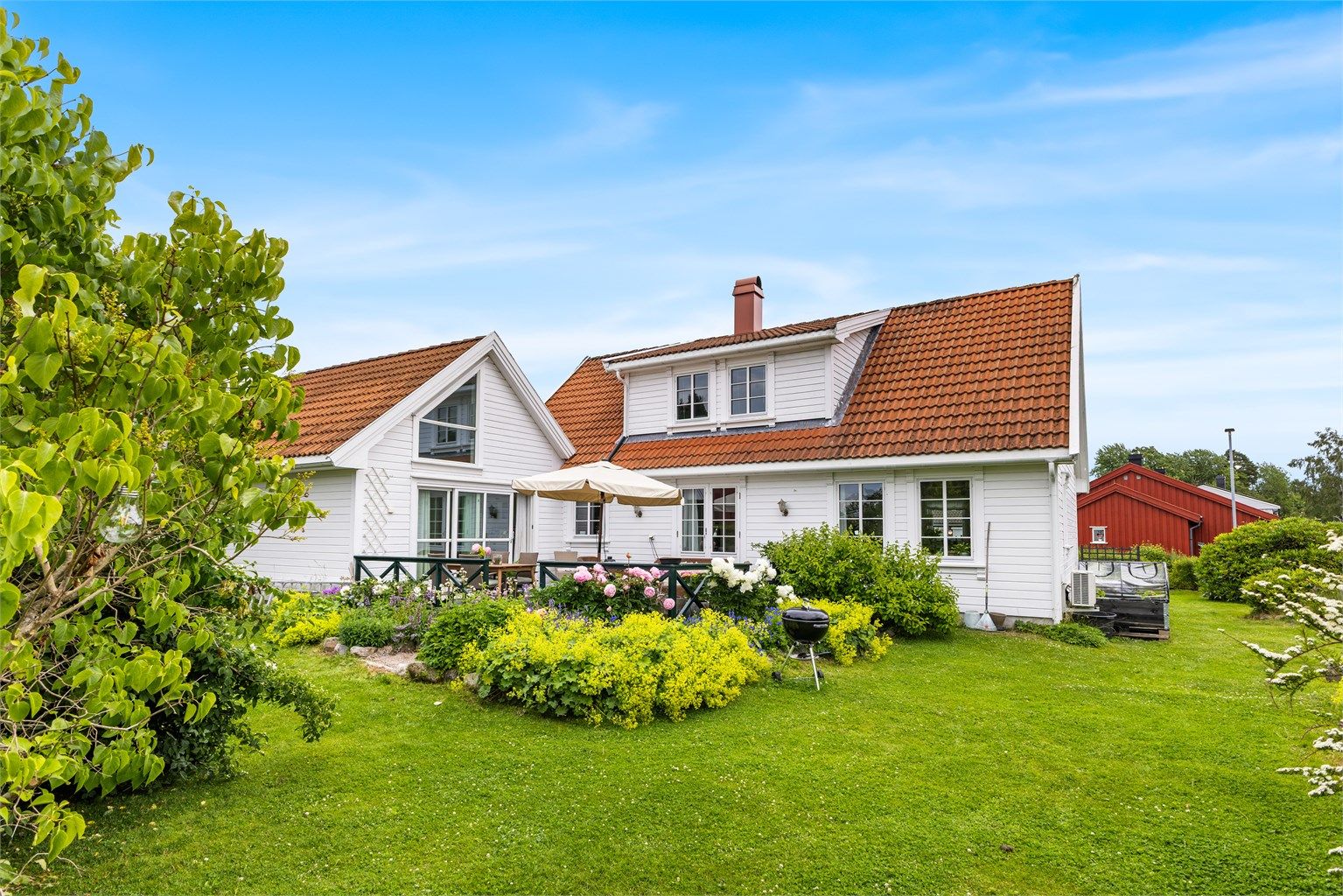 Eiendommen har en frodig og usjenert hage med en stor terrasse som en naturlig samlingsplass.