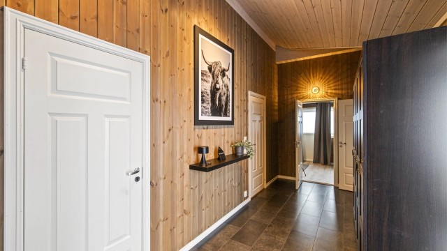 Hall med tilgang til hovedsoverom, bad og vaskerom - før man entrer inn til kjøkkenet