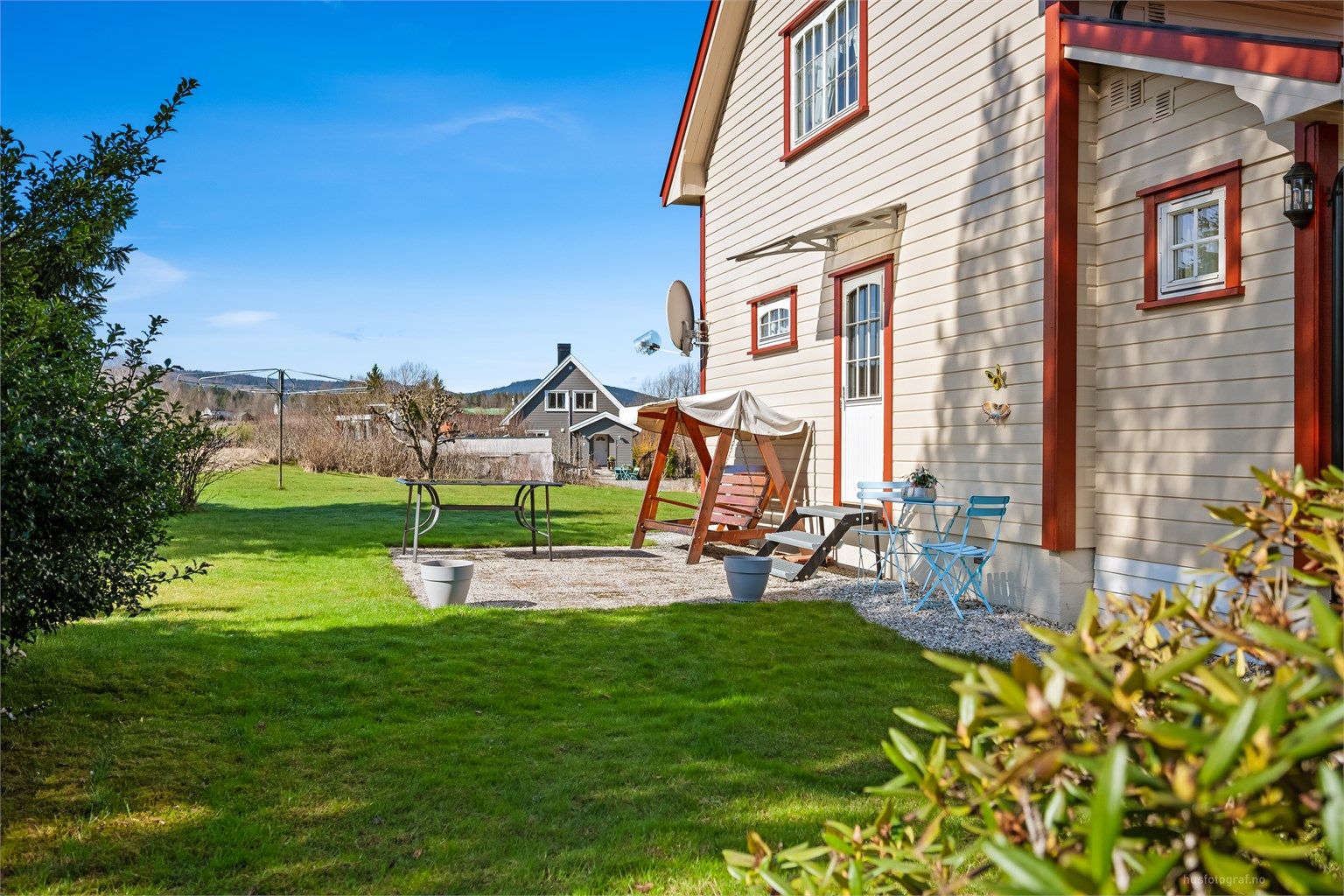 Tomten er opparbeidet med plenarealer og en sydøstvendt uteplass med rom for utemøbler.