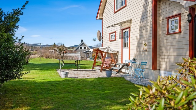 Tomten er opparbeidet med plenarealer og en sydøstvendt uteplass med rom for utemøbler.