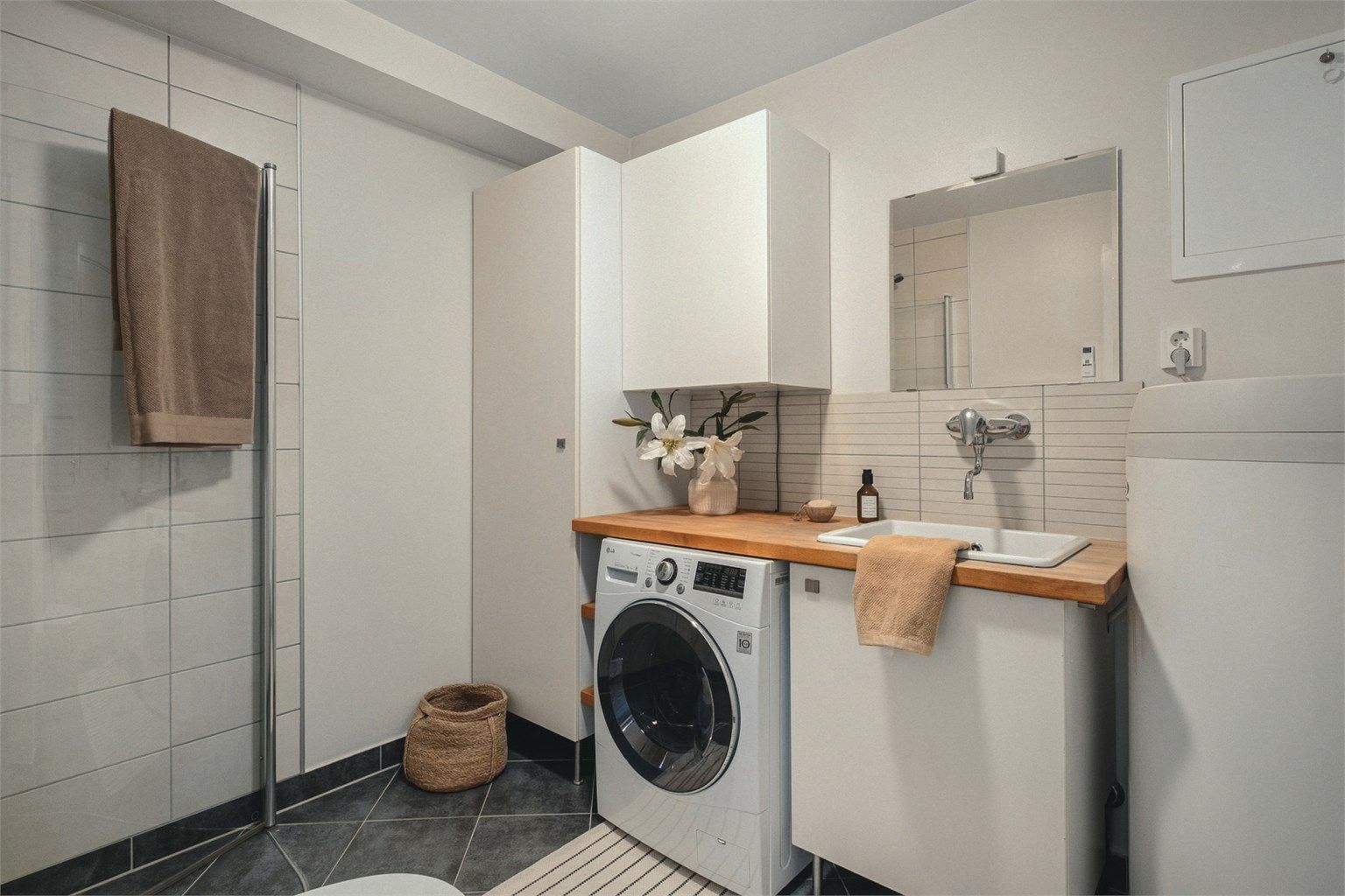 Badet i underetasjen er delvis fliset med gulvvarme og er innredet med baderomsmøbler, dusjhjørne og vegghengt wc