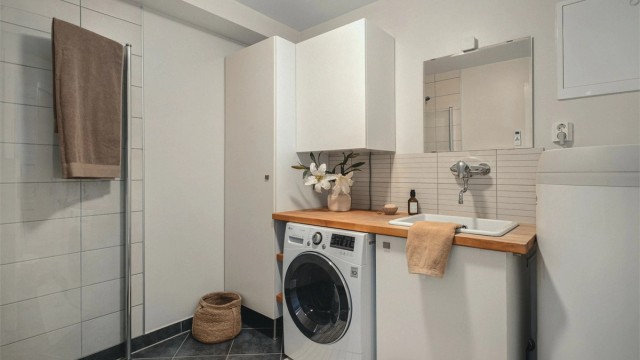 Badet i underetasjen er delvis fliset med gulvvarme og er innredet med baderomsmøbler, dusjhjørne og vegghengt wc