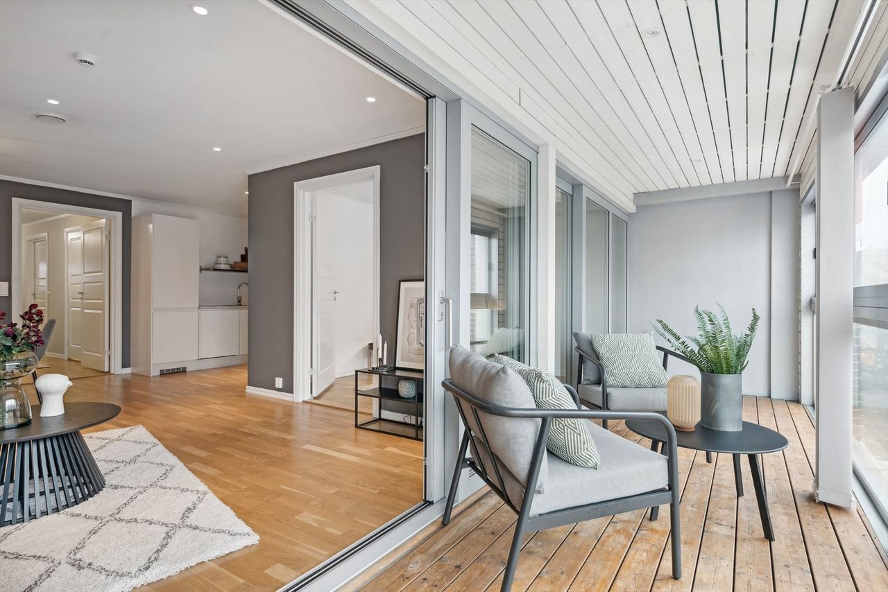 Verandaens gulv og himling er utført med lyst trepanel fremfor kald betong. Innfelte spotter besørger effektfull belysning.