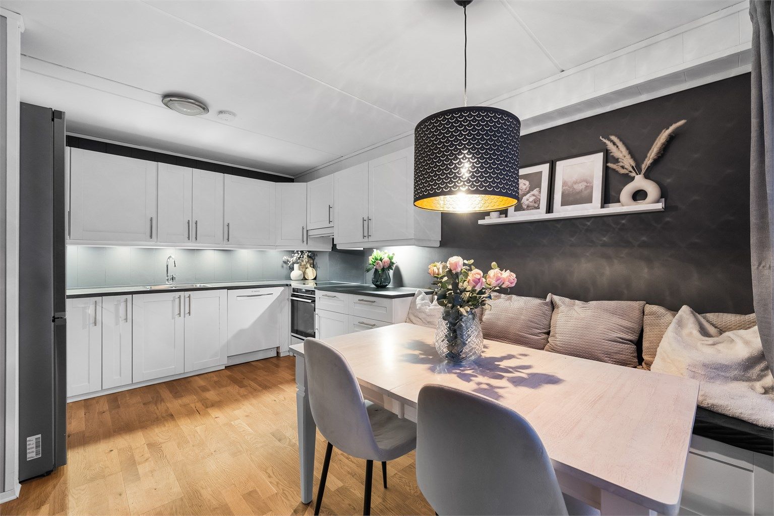 Den åpne løsningen mellom stue og kjøkken skaper en sosial og luftig atmosfære.