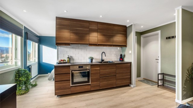 Et funksjonelt og arealeffektivt kjøkken med skap- og benkeplass.