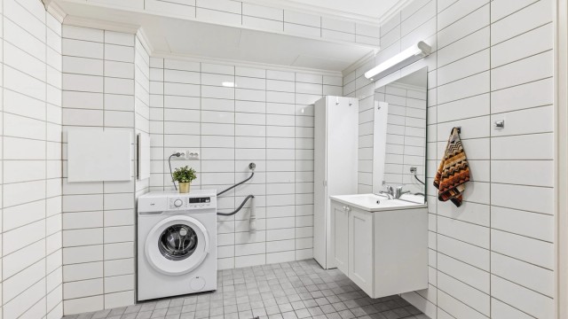 En smart detalj er skittentøyssjakten fra loftsetasjen som ender her på vaskerommet.