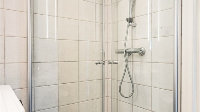 Svingbare glassdører gir et luftig inntrykk, mens mønstrede gulvfliser gir badet et fint særpreg.