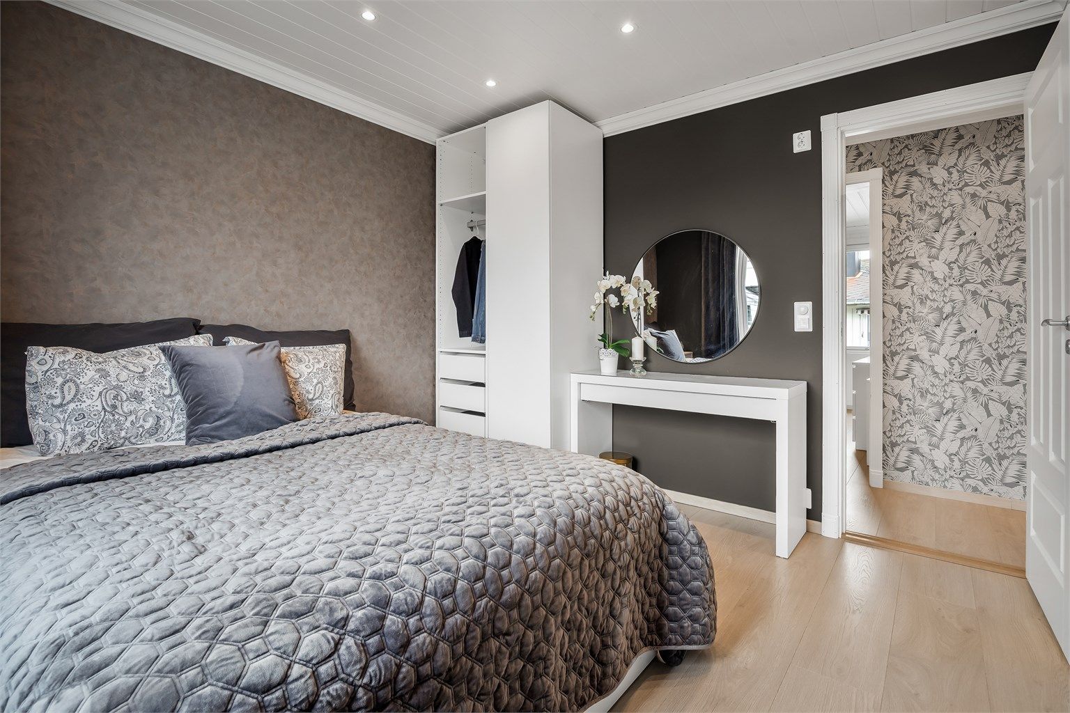 Romslig soverom med god plass til dobbeltseng og tilhørende møblement.
