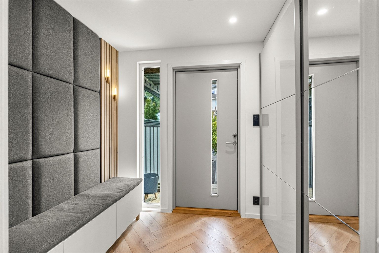 Innbydende entré med plassbygd sittebenk og rikelig med garderobeplass bak speildører.