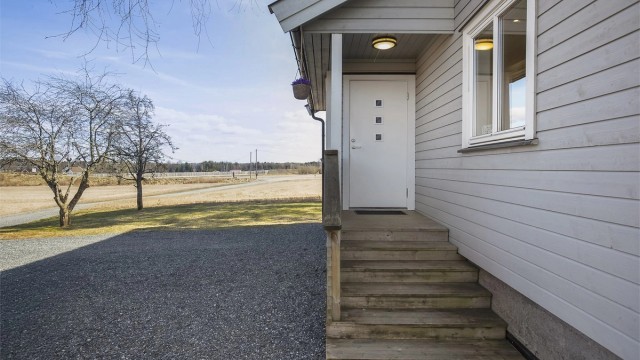 Gruslagt gårdsplass med rikelig parkeringsplass for flere biler.