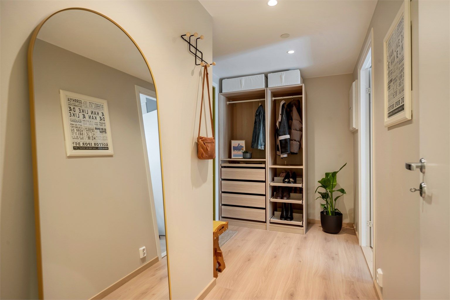 Innbydende entré med downlights i himling. Rommet har god plass til oppheng av yttertøy og plassering av skotøy.