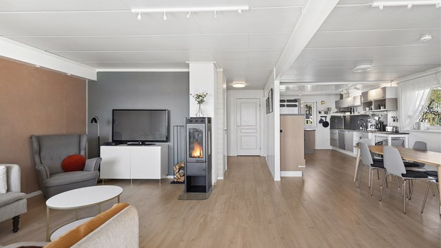 Kjøkken i åpen løsning mot stuen gir en luftig og sosial atmosfære. Her er det god plass til en romslig sittegruppe og en stor spiseplass, perfekt for både hverdag og fest.