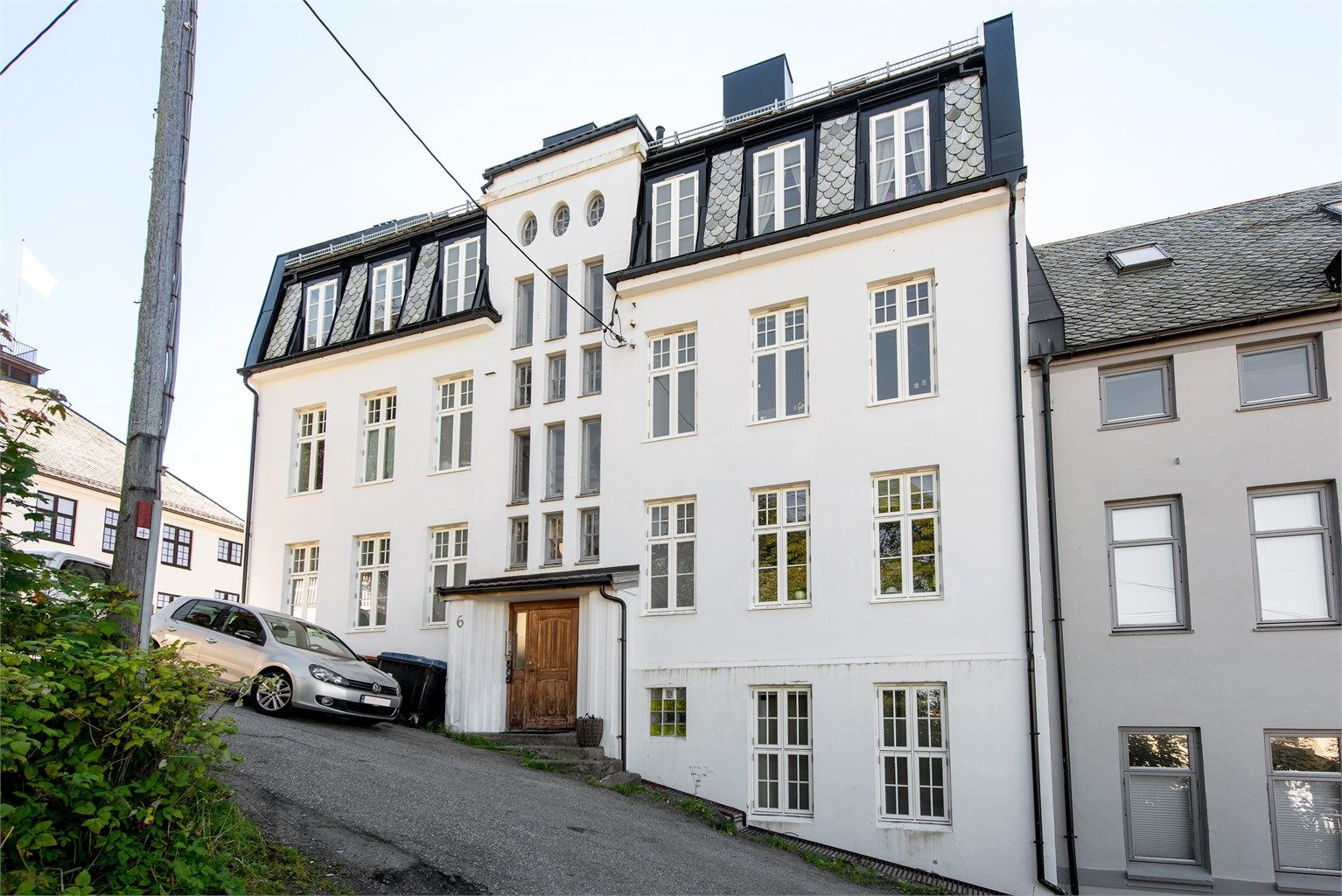 Klassisk bygård fra 1916 med murpusset fasade og mansardtak belagt med skifer.