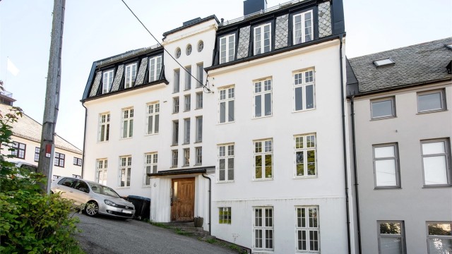Klassisk bygård fra 1916 med murpusset fasade og mansardtak belagt med skifer.