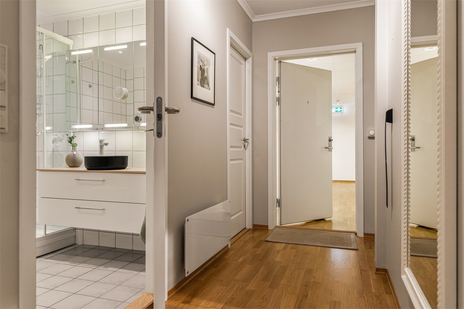 Fra entréen er det direkte adkomst til badet og videre inn i leiligheten.