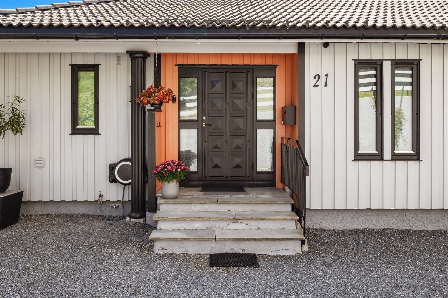 Fra gårdsplassen er det utvendig skiferbelagt trappeadkomst til boligens overbygde inngangsparti i 1. etasje.