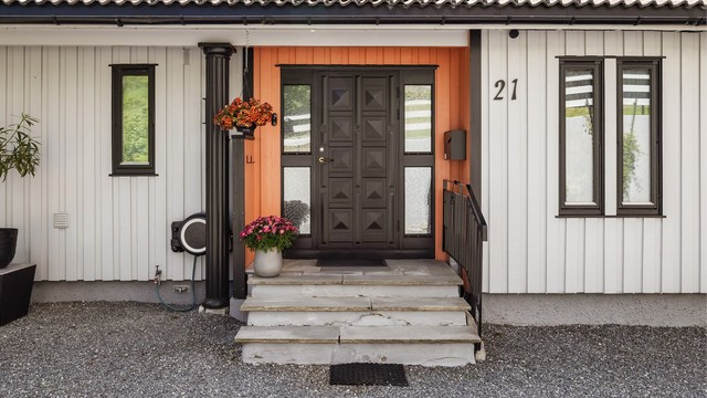 Fra gårdsplassen er det utvendig skiferbelagt trappeadkomst til boligens overbygde inngangsparti i 1. etasje.