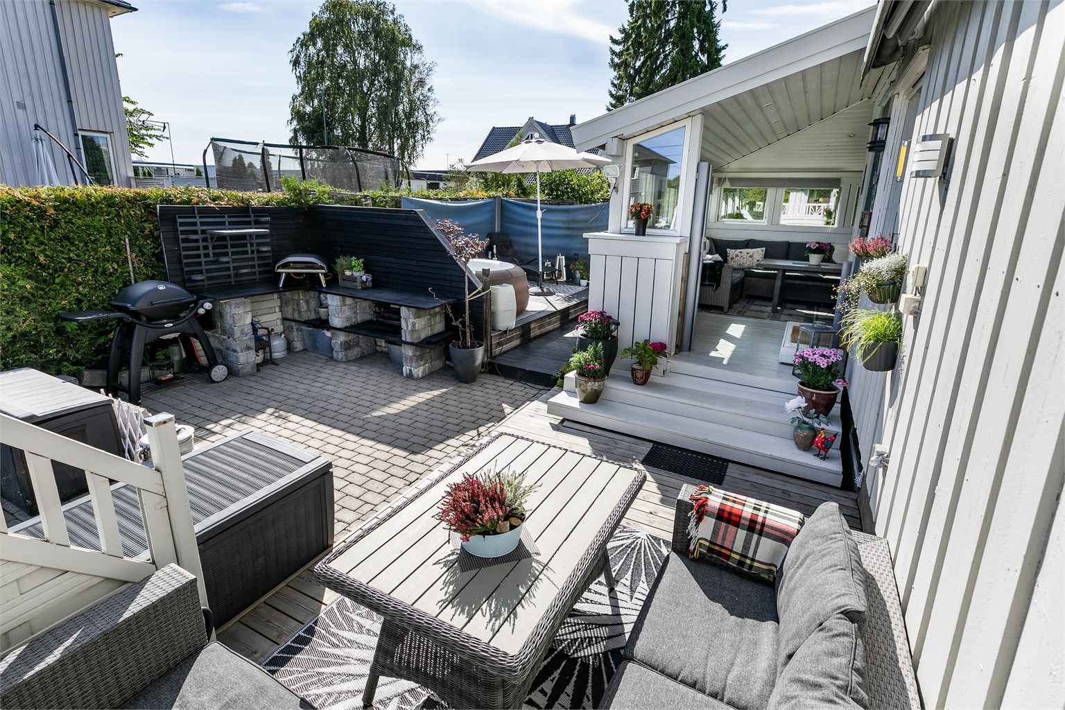 Solfylt uteplass foran inngangspartiet, med mulighet for utekjøkken.