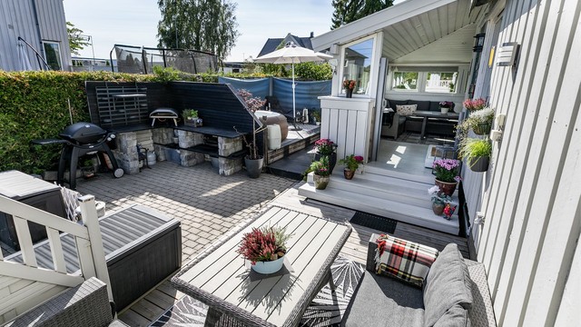 Solfylt uteplass foran inngangspartiet, med mulighet for utekjøkken.