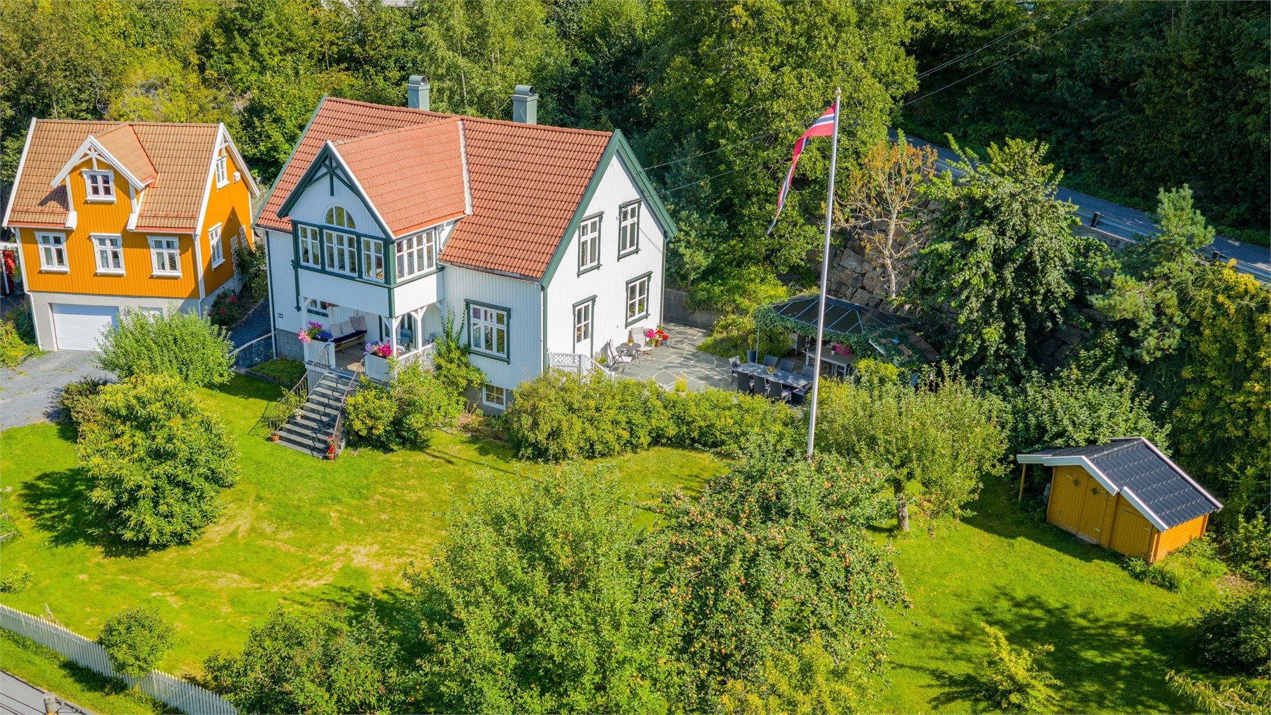 Meget innholdsrik og velstelt tomt- solrik uteplass, frukttrær, bærbusker, blomster, pergola, terrasse og parkering både i garasje og på tomten.