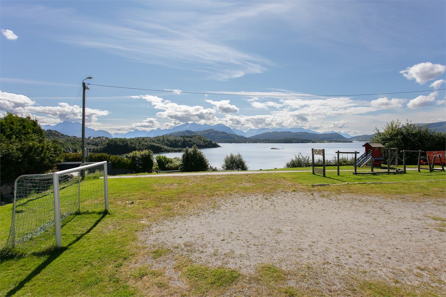 Lekeareal med utsikt over fjorden og omkringliggende fjell.