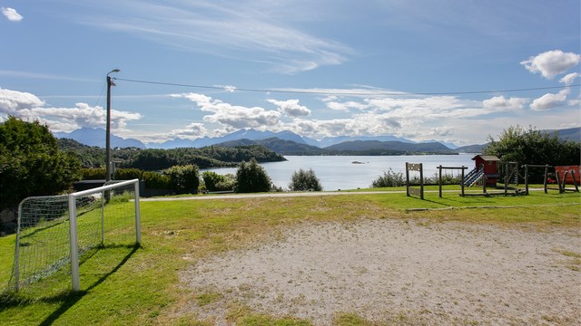 Lekeareal med utsikt over fjorden og omkringliggende fjell.