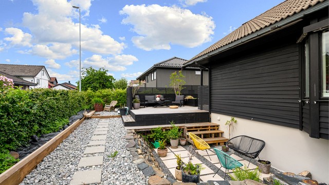Pent opparbeidet hage med heller og grusganger.