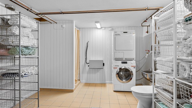 Vaskerom med flislagt gulv med varme i kjelleretasjen. Innredet med vegghengt utslagsvask. Dusjhjørne med forheng og gulvstående toalett. Opplegg for vaskemaskin.
