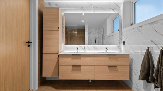 Badet har dobbel vask og rikelig med lagringsplass i skuffer og høyskap.