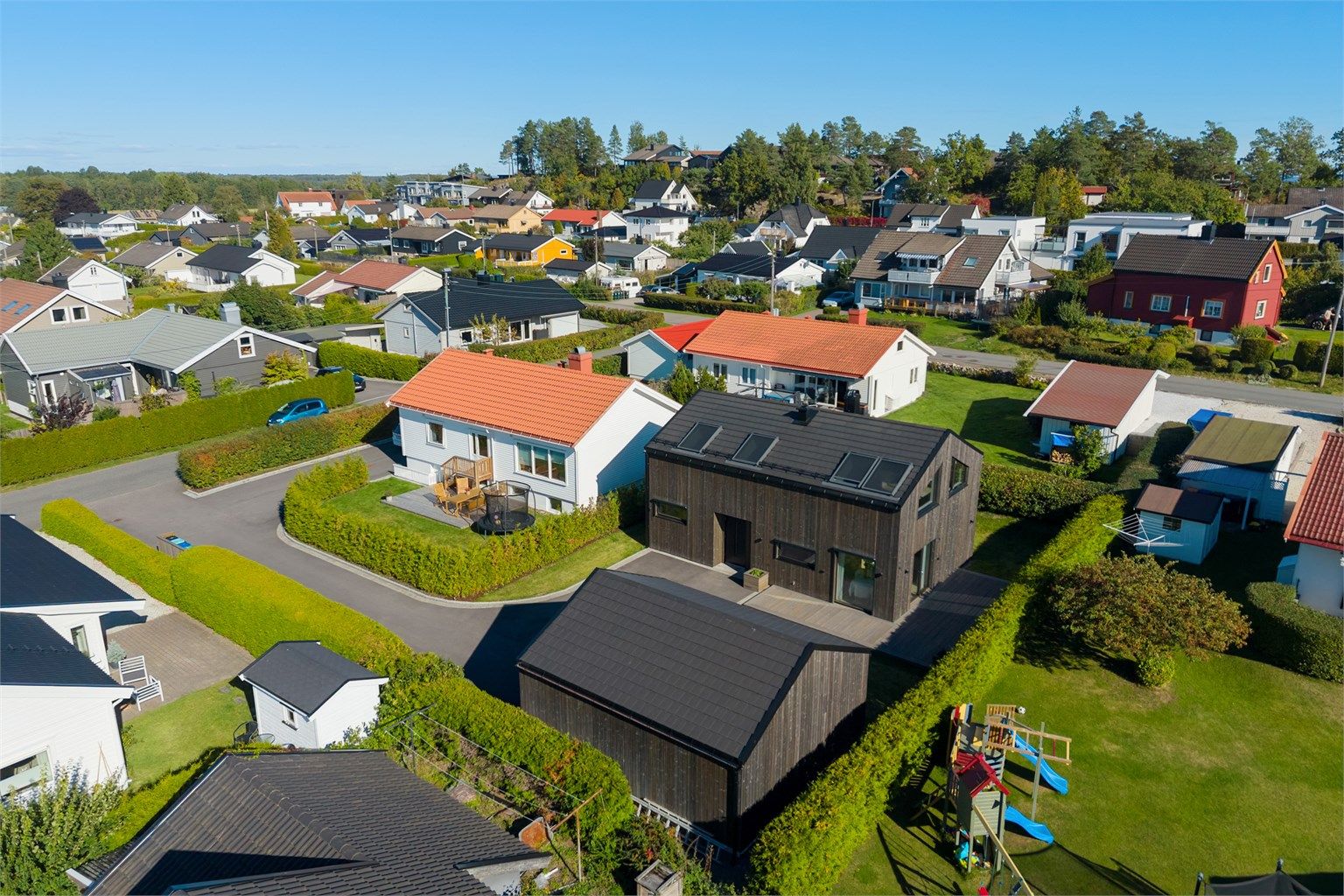 Eiendommen har asfaltert innkjørsel, dobbelgarasje og flat tomt.