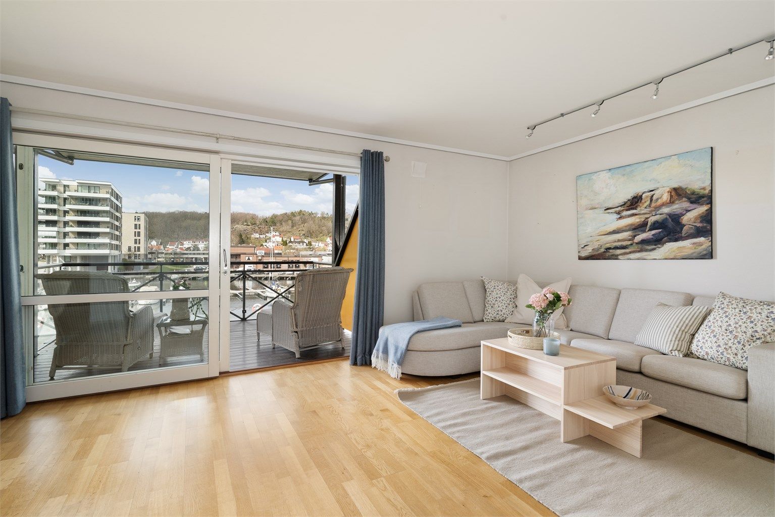 Store skyvedører i glass åpner opp mot balkongen og trekker utsikten og lyset inn i stuen.