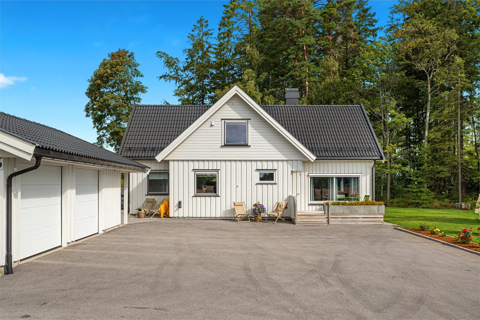 Stor asfaltert gårdsplass samt dobbel garasje