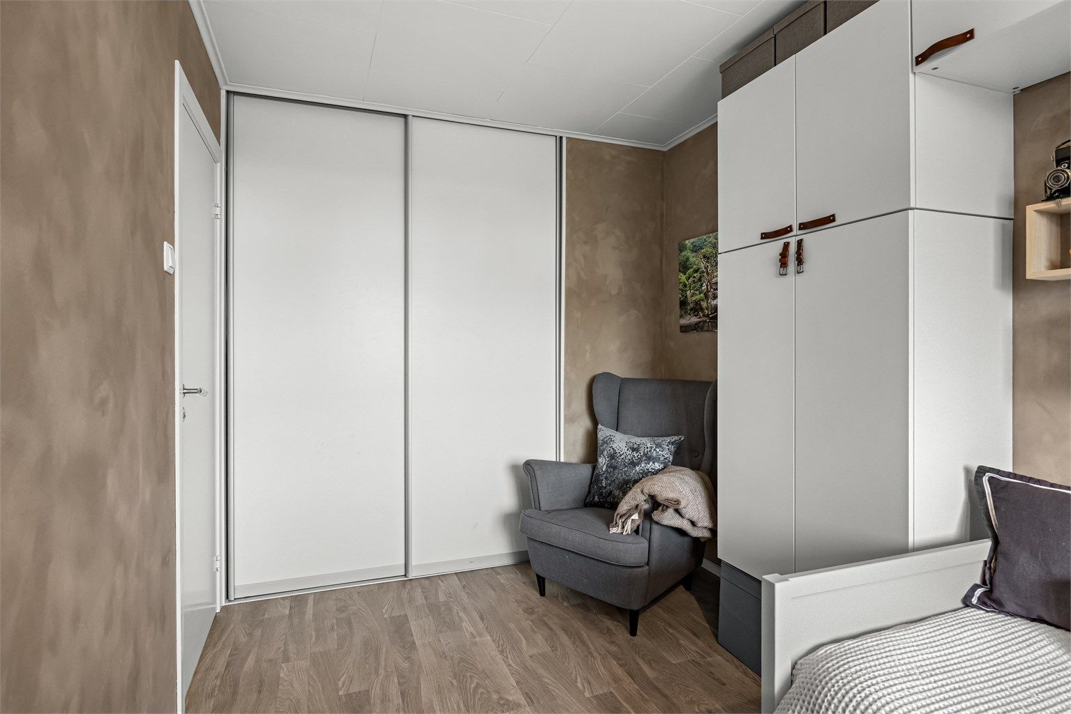 Innebygd skyvedørsgarderobe gir rikelig med ekstra oppbevaring i rommet.