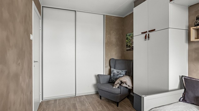 Innebygd skyvedørsgarderobe gir rikelig med ekstra oppbevaring i rommet.