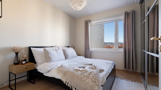 Soverom av god størrelse og god plass til dobbeltseng med tilhørende nattbord på begge sider av sengen.