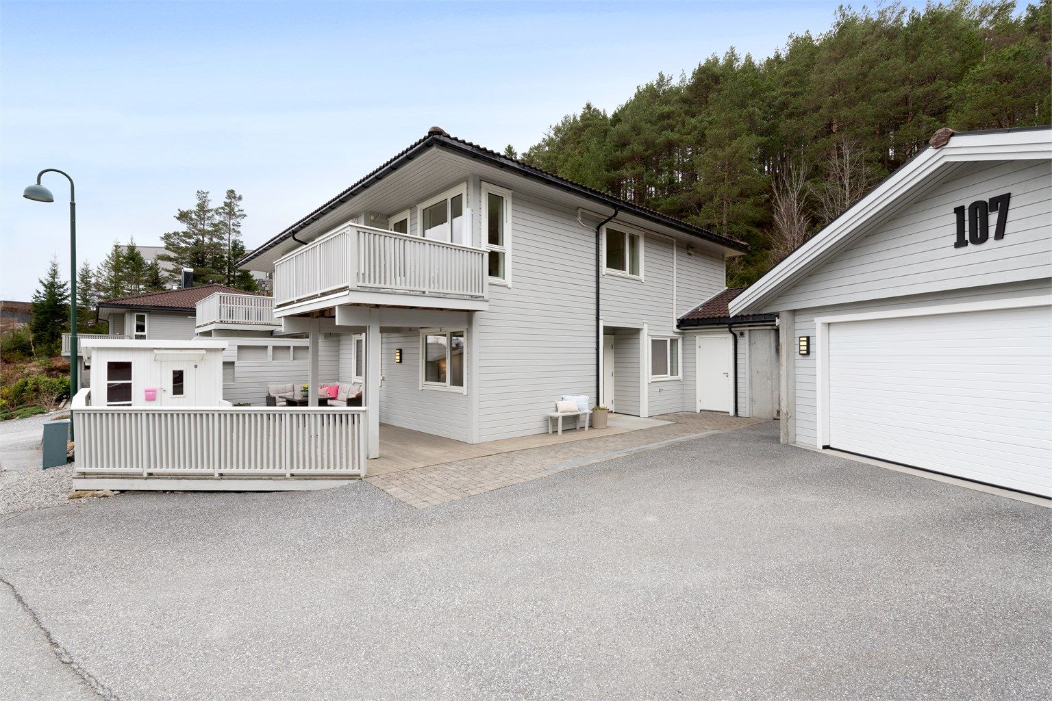 Asfaltert gårdsplass med enkel adkomst til både bolig og garasje.