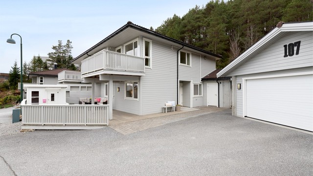 Asfaltert gårdsplass med enkel adkomst til både bolig og garasje.