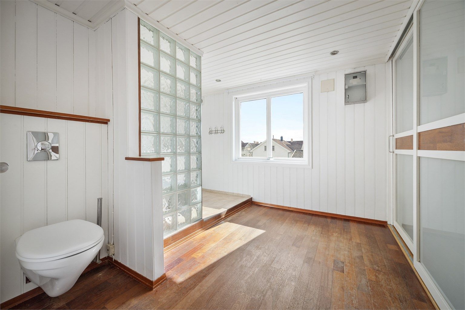 Delvis flislagt bad med malte paneler på vegger og tak. Skyvedørsgarderobe med god plass til oppbevaring.