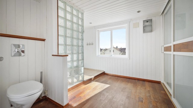 Delvis flislagt bad med malte paneler på vegger og tak. Skyvedørsgarderobe med god plass til oppbevaring.