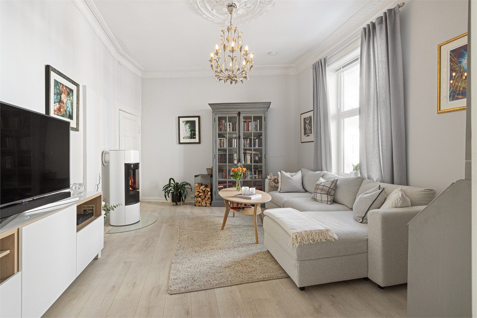 En innbydende stue med en-stavs laminat og peisovn fra 2022.